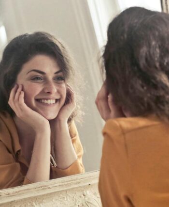 woman smiling looking in mirror