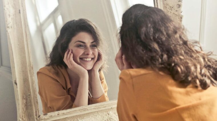 woman smiling looking in mirror