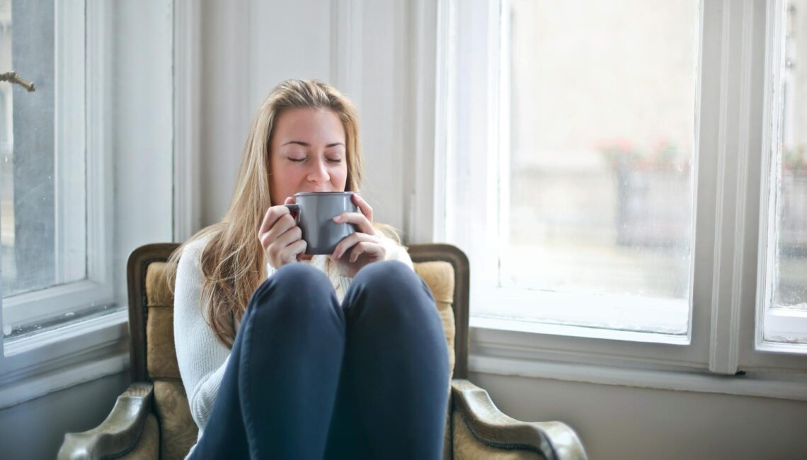 woman sitting in chair drinking coffee