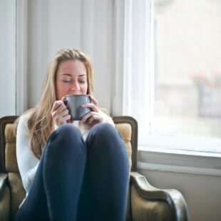 woman sitting in chair drinking coffee