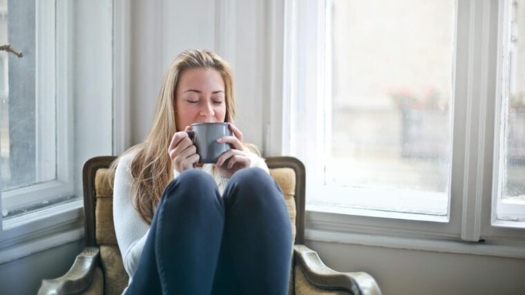 woman sitting in chair drinking coffee